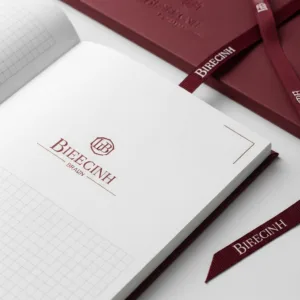 Primer plano centrado en los elementos de marca detallados de los cuadernos personalizados a granel, una hoja de guarda impresa a medida, un diseño exclusivo de la página interior y un elegante marcador de cinta con la marca.