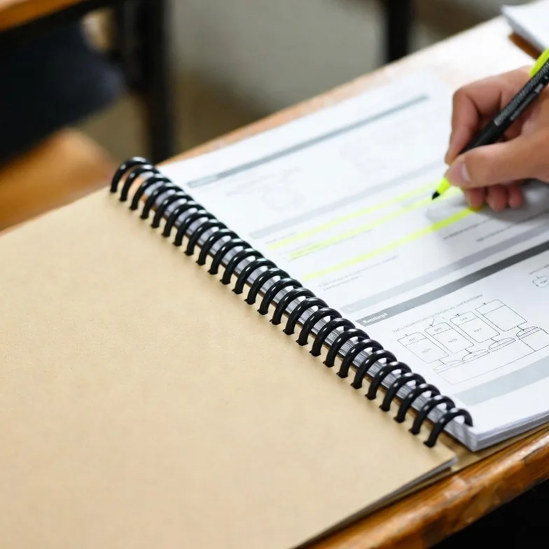 Spiral Bound Training Workbook On A Student Desk.