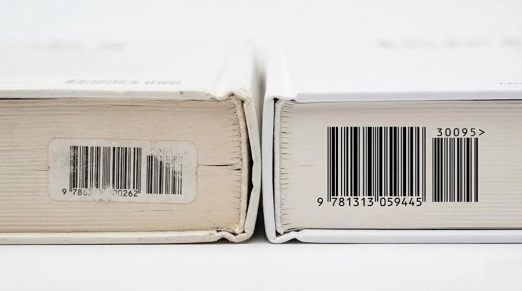 A Side By Side Macro Comparison Of A Poorly Bound Book And A Professionally Printed Hardcover With A Compliant Barcode.