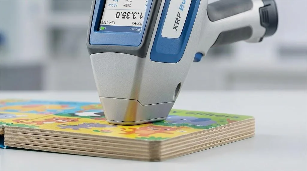 Un analyseur Xrf portatif effectuant un contrôle de sécurité des métaux lourds sur la surface vibrante d'un livre de lecture pour enfants. Un analyseur Xrf portatif effectuant un contrôle de sécurité des métaux lourds sur la surface vibrante d'un livre de lecture pour enfants.