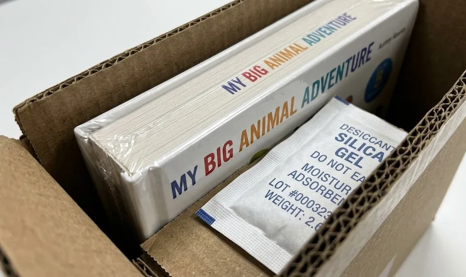 Vakuumversiegeltes Pappbuch mit industrieller Trockenmittelpackung Chinesischer QC-Techniker bei der Überprüfung der Druckspezifikationen für Kinderbücher