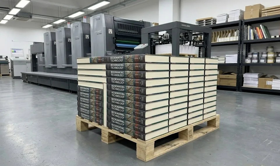 Libros de arte de tapa dura de alta calidad apilados en un palé logístico