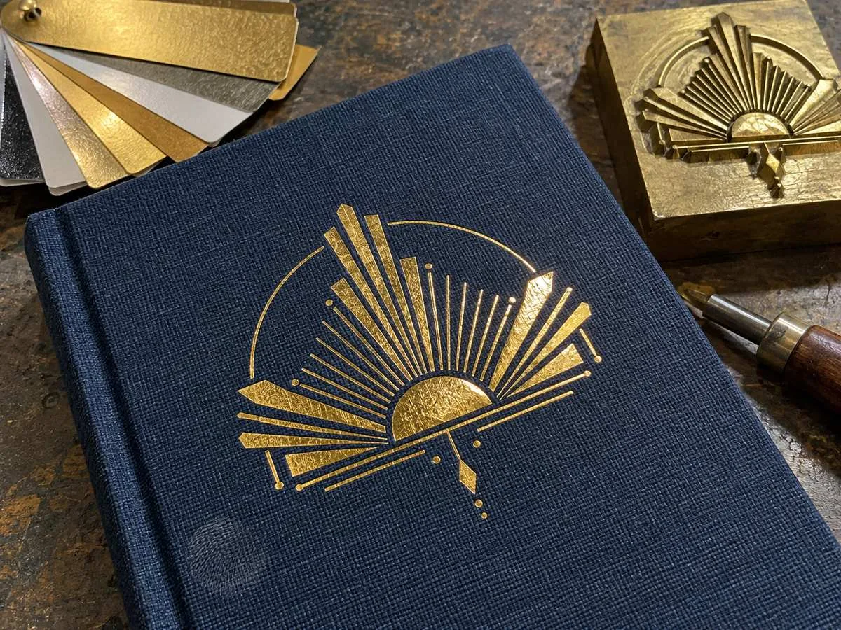 gold foil stamped logo on navy cloth notebook cover